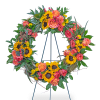 Circular floral wreath with sunflowers, orange roses, and pink blooms