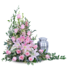 Pink roses and lilies arranged beside a silver urn