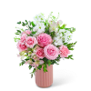 Pink roses and white flowers arranged in a pink vase
