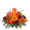 Orange candle surrounded by orange and burgundy flowers