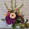 Mixed bouquet in a clear glass vase with pink and cream blooms