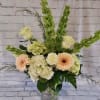 Mixed bouquet with pale roses, gerbera daisies, and hydrangeas in a glass vase
