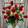 Bouquet of red roses and white filler flowers in a clear glass vase