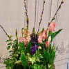 Tall floral arrangement with pink tulips, purple blooms, and pussy willow branches