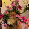 Basket arrangement of pink and white flowers with a ribbon