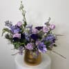 Lavender roses and deep purple anemones combine in a garden-style bouquet that
