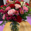 Mixed bouquet of pink and red flowers in a clear glass vase