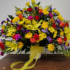 Large mixed bouquet with yellow lilies, roses, and daisies in a white vase