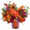 Orange roses and mixed autumn flowers in a striped glass vase