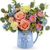 Mixed bouquet of roses, carnations, and daisies in a blue pitcher vase