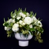 White floral arrangement in a white pedestal vase