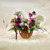 Mixed flower arrangement in a wicker basket with red and pink roses