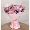 Pink and lavender bouquet wrapped in pale pink paper with a ribbon