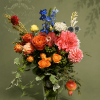 An elegant arrangement of warm garden roses, vibrant dahlias, seasonal blooms, and