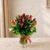 Red roses in a clear glass vase with a red polka-dot ribbon