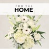 White floral arrangement with roses, lilies, and daisies in a vase