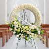 White floral wreath and bouquet on an easel with a "LOVE FROM HOPE" ribbon