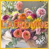 Mixed bouquet of orange, pink, yellow, and purple flowers wrapped in paper