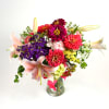 Colorful bouquet of zinnias and lilies in a glass vase