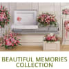 Pink floral funeral casket spray with matching standing wreaths and vase arrangements