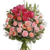 Pink tulips and peach roses in a clear glass vase