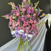 Large bouquet of pink and purple flowers tied with lavender and white ribbons