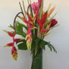 Tropical flowers in tall glass vase