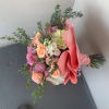 Bouquet of pink, peach, and white flowers wrapped in pink paper
