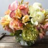 Mixed bouquet of pastel flowers in a glass vase