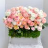 Box arrangement of pink, peach, and white ranunculus flowers
