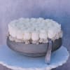 Round arrangement of white roses in a gray bowl with a ribbon