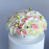 Round bouquet of pink and white roses on a white pedestal