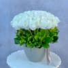 Round bouquet of white roses in a speckled gray vase