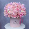 Pink rose and hydrangea arrangement in a round hat box with ribbon