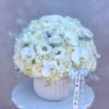 White rose and orchid arrangement in a ribbed white vase