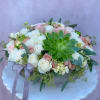 Round bouquet of white and blush roses with a green succulent centerpiece