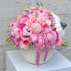 Pink floral arrangement in a white pumpkin-shaped vase with a ribbon bow