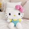 Hello Kitty plush toy sitting on a bed with a pink bow