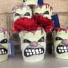 Red carnations arranged in a skull-shaped planter