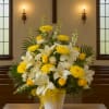 Yellow and white floral arrangement in a white vase