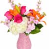 Pink and orange bouquet with roses, lilies, hydrangea, and a pink vase