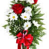 Red roses and white daisies in a glass vase with a red ribbon