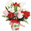 Bouquet of red carnations, pink roses, and white calla lilies in a white vase
