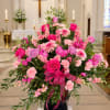 Large pink and lavender floral arrangement in a church setting