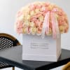 Large box arrangement of pink and cream roses with ribbon