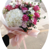 A striking cluster of white hydrangea meets bright pink roses in this