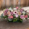 Pink and white mixed flower arrangement in a rectangular glass vase