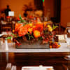 Orange floral centerpiece in a wooden box on a banquet table