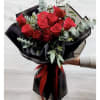 Bouquet of red roses wrapped in black paper with a red ribbon