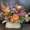 Basket arrangement with orange and purple flowers